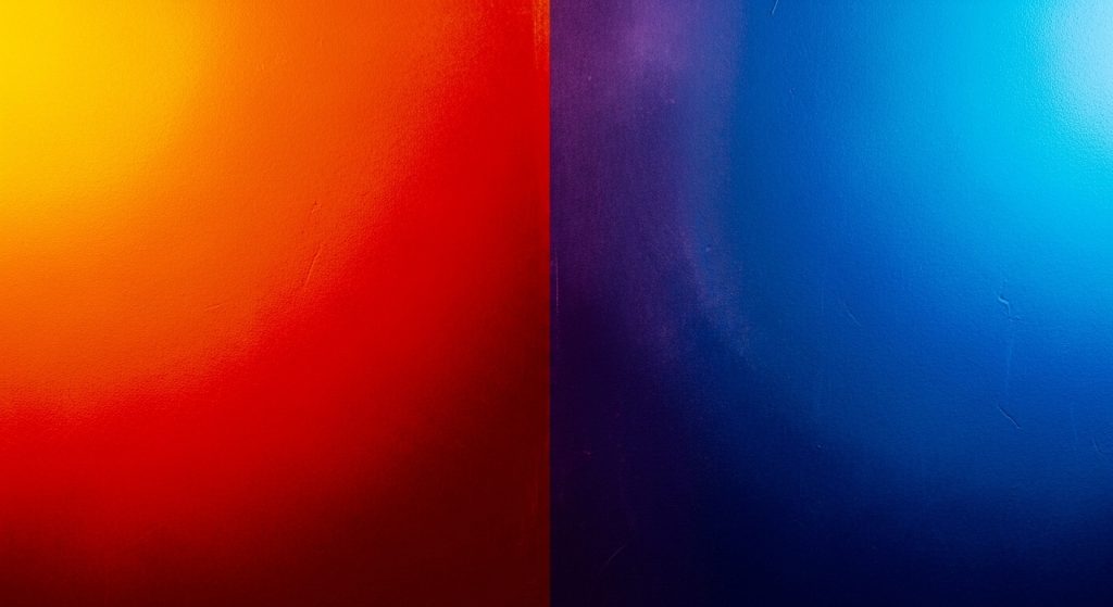 Fundo abstrato com forte contraste entre cores complementares. O lado esquerdo apresenta um gradiente vibrante de amarelo, laranja e vermelho, enquanto o lado direito exibe tons profundos de azul e roxo. Ideal para estudo de teoria das cores e impacto visual